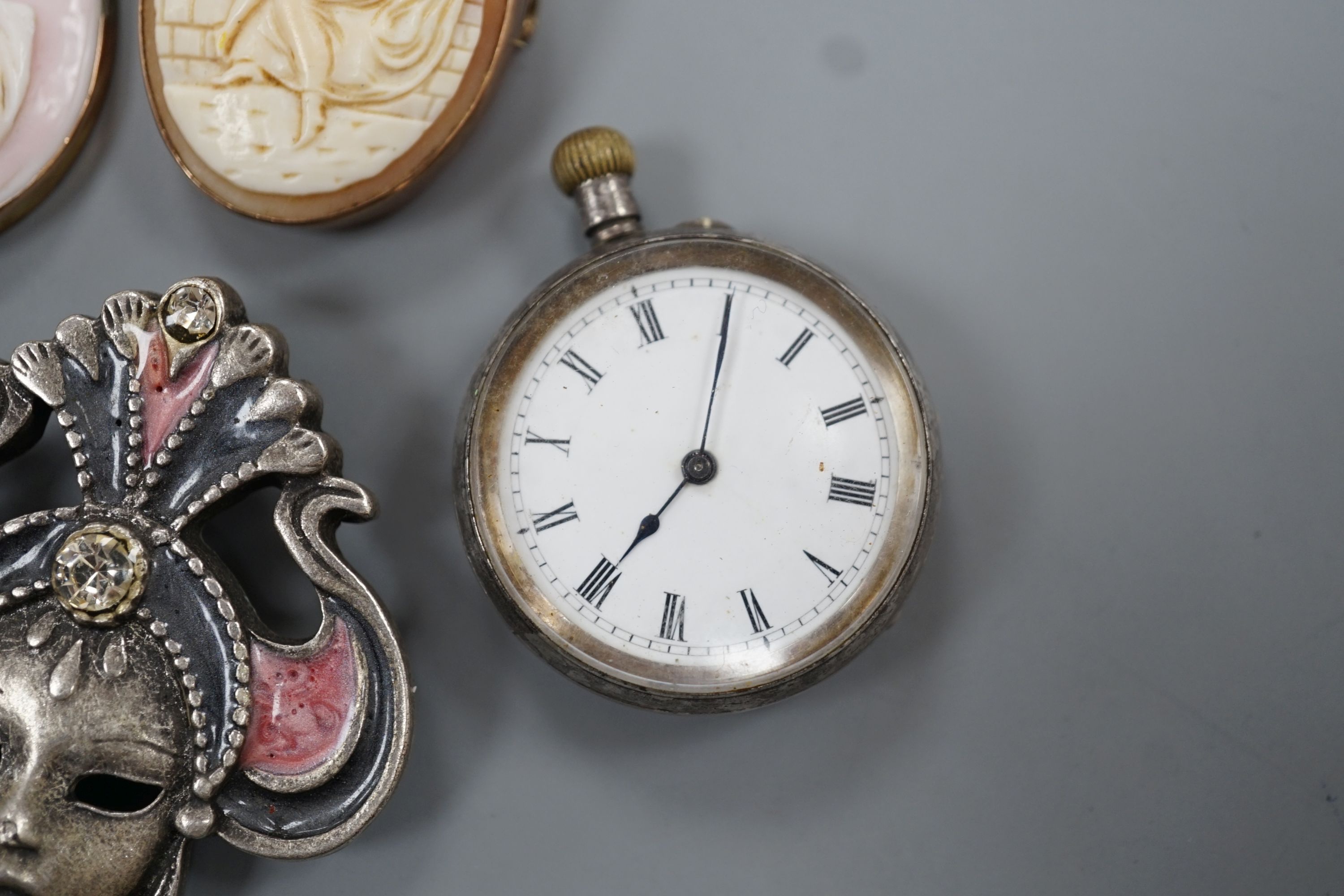 A yellow metal mounted cameo shell brooch and a similar pendant, two brooches, a white metal fob watch and one other brooch.